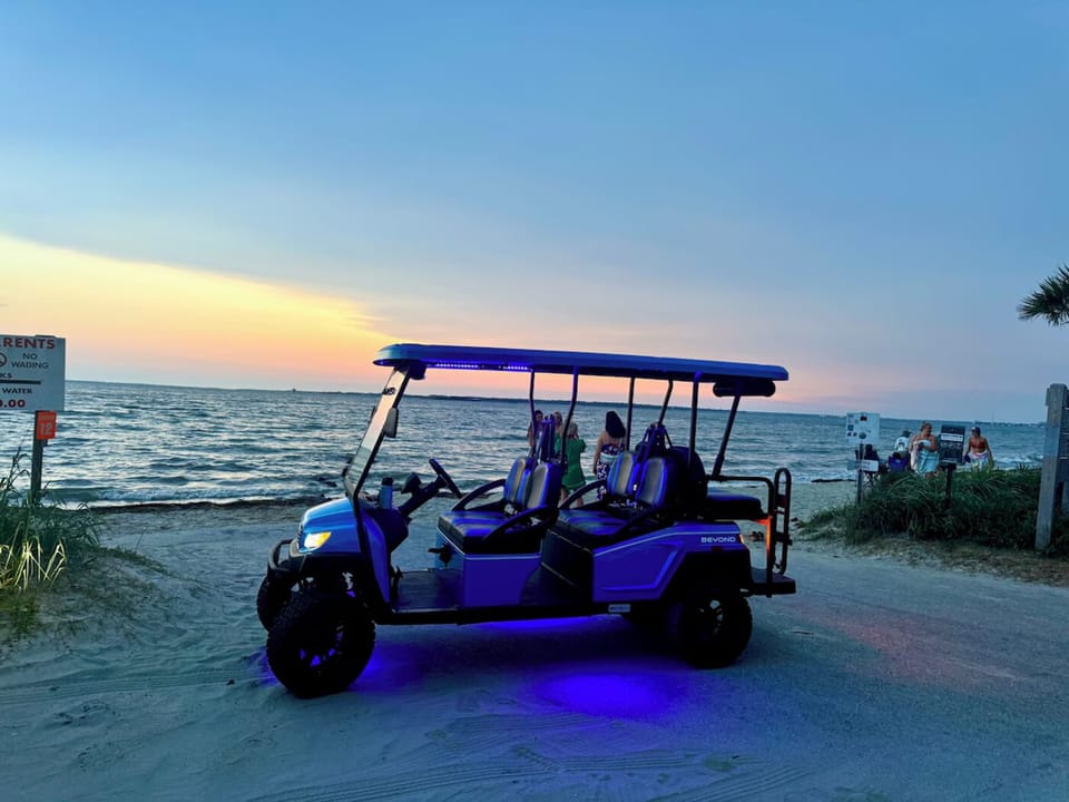 The six-seat golf cart parked at the beach at sunset