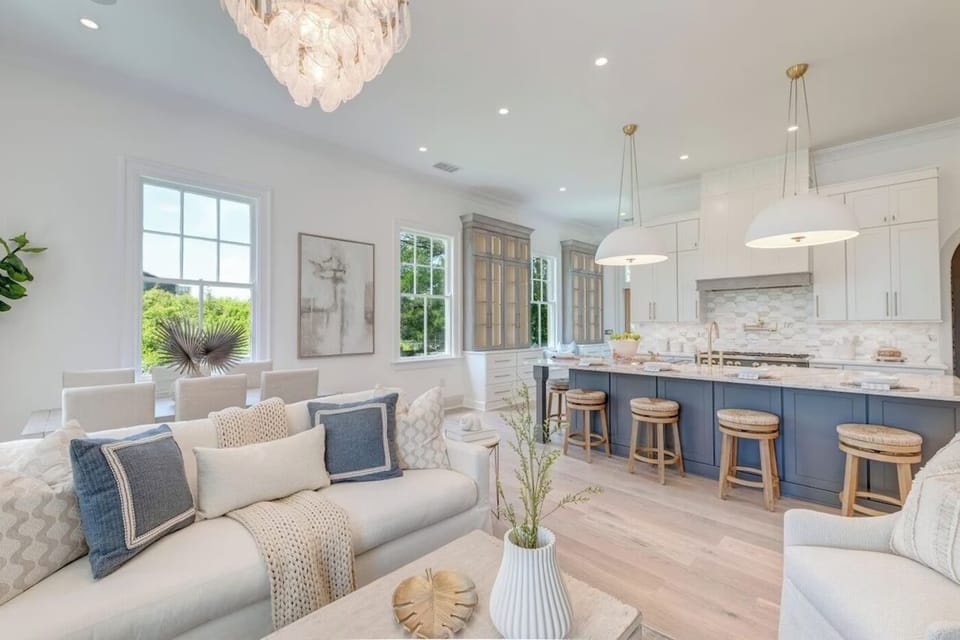 Living room open to the kitchen, under a shell chandelier