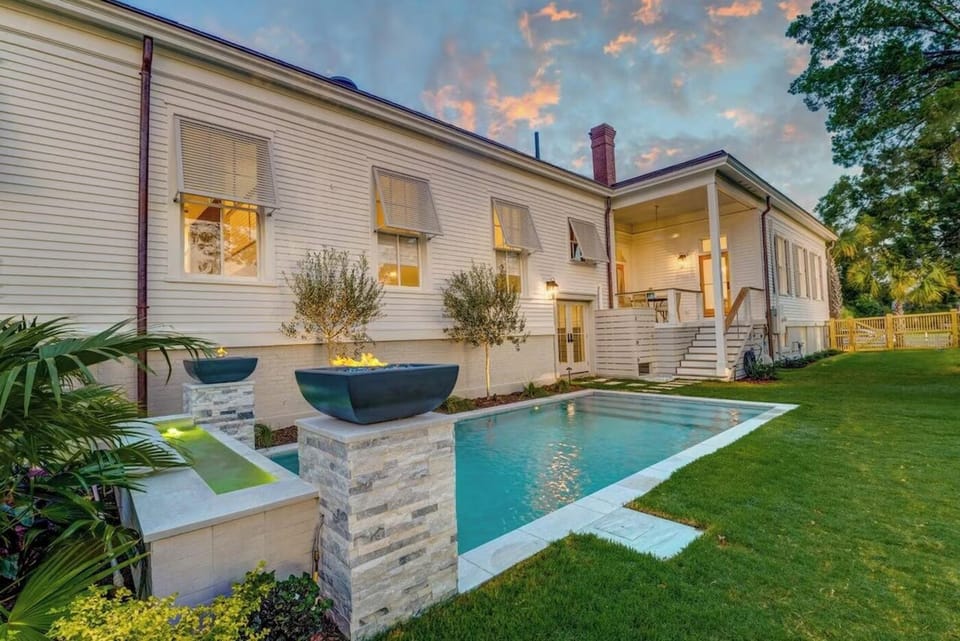 Pool and fire bowls at dusk behind the house