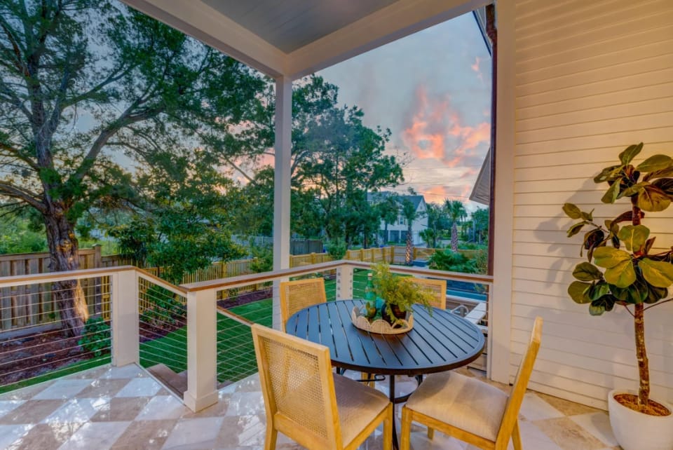 Covered back porch at sunset, looking over the lawn and pool